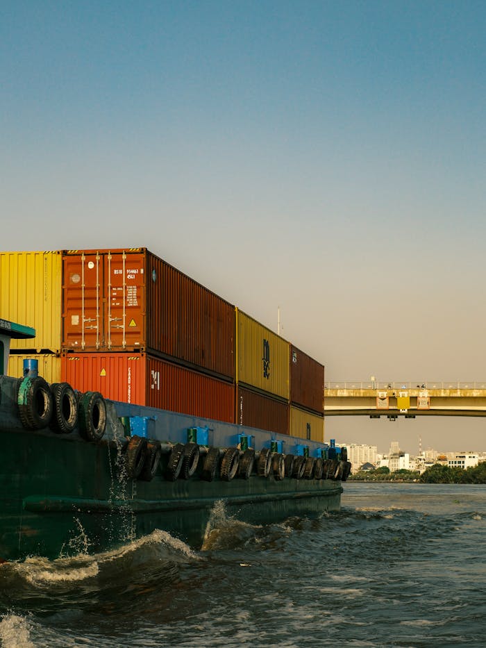 Mastering the First Impression: Your intriguing post title goes here Industrial container ship navigating Saigon River under a clear sky with a cityscape in the background.